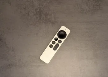 Neues Apple TV 4K: silberne Siri Remote liegt diagonal auf einer grauen Steinfläche