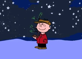 Charlie Brown mit kleinem Weihnachtsbaum unter Sternenhimmel im Schnee, Szene aus A Charlie Brown Christmas, das bei Apple TV wieder gratis läuft