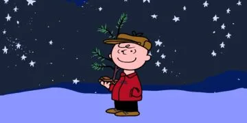 Charlie Brown mit kleinem Weihnachtsbaum unter Sternenhimmel im Schnee, Szene aus A Charlie Brown Christmas, das bei Apple TV wieder gratis läuft