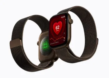 Apple Watch Series 12 mit Milanaise-Armband, vorn die Herzfrequenz auf dem Zifferblatt, dahinter der leuchtende Herzsensor auf der Rückseite