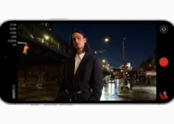 Final Cut Camera auf einem iPhone 18 Pro im Querformat mit eingeblendeter Blende f/1,48 bei einer Nachtaufnahme eines Mannes auf einer Straße in der Stadt