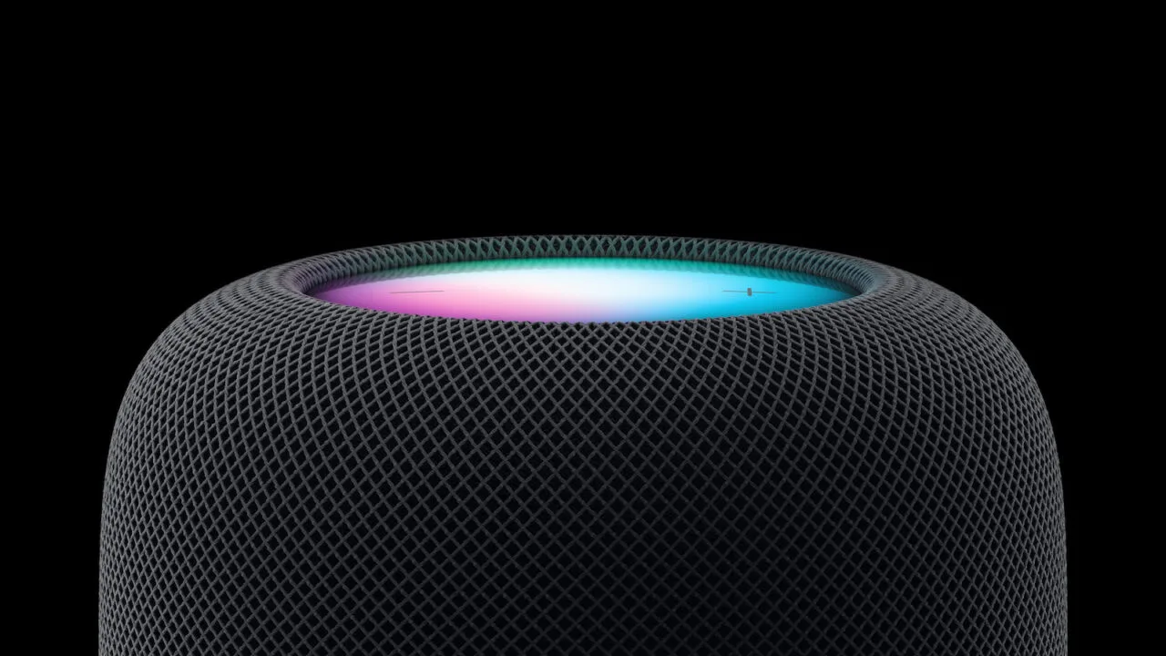 HomePod Siri AI: Oberseite eines HomePod in Mitternacht mit leuchtendem Siri-Ring in Pink und Türkis vor schwarzem Hintergrund