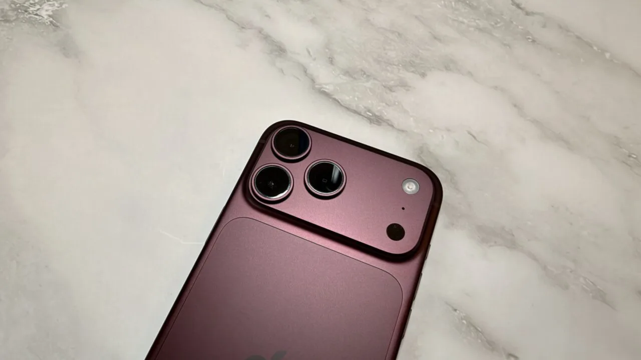 Kamerasystem eines iPhone 18 Pro Max in Burgunderrot aus der Nähe auf hellem Marmor – die Hauptkamera, mit der das iPhone 18 Pro Kinomodus-Effekte und Zeitraffer in 4K aufnimmt