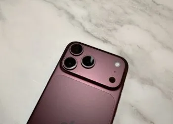 Kamerasystem eines iPhone 18 Pro Max in Burgunderrot aus der Nähe auf hellem Marmor – die Hauptkamera, mit der das iPhone 18 Pro Kinomodus-Effekte und Zeitraffer in 4K aufnimmt
