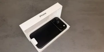iPhone 18 Pro Max in Schwarz mit der Rückseite nach oben in der geöffneten Originalverpackung auf grauem Steinuntergrund