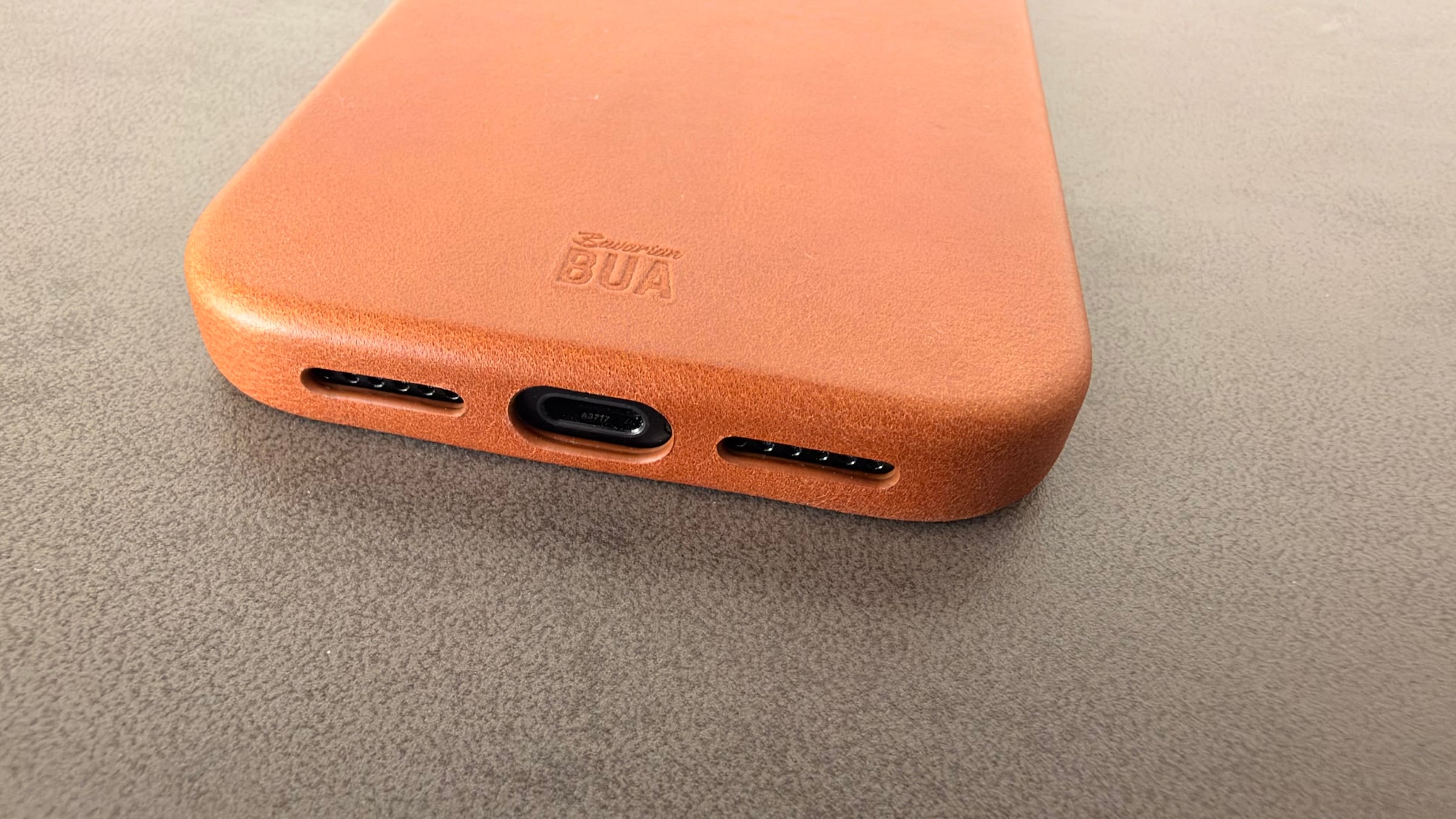 Bottom edge of the leather case for the iPhone 18 Pro Max with cutouts for the USB-C port and speakers and an embossed Bavarian BUA logo