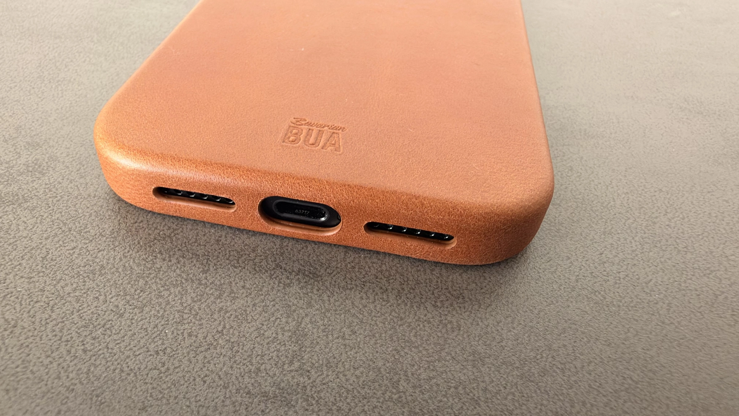 Unterkante der Lederhülle für das iPhone 18 Pro Max mit Aussparungen für USB-C-Anschluss und Lautsprecher sowie geprägtem Bavarian-BUA-Logo