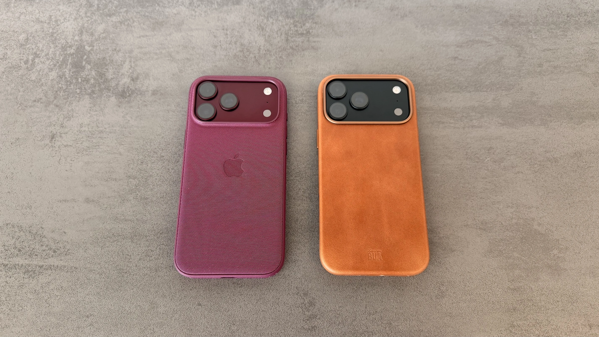 Lederhülle für das iPhone 18 Pro Max in Hellbraun neben Apples Funktionsgewebe Case in Burgunder, beide auf grauem Untergrund