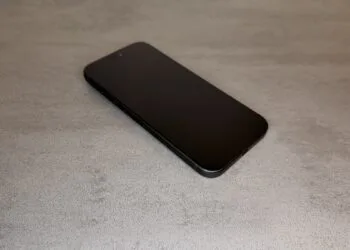 iPhone 20 Display im Vergleich: aktuelles schwarzes iPhone Pro mit flachem Display schräg von oben auf grauer Steinoberfläche