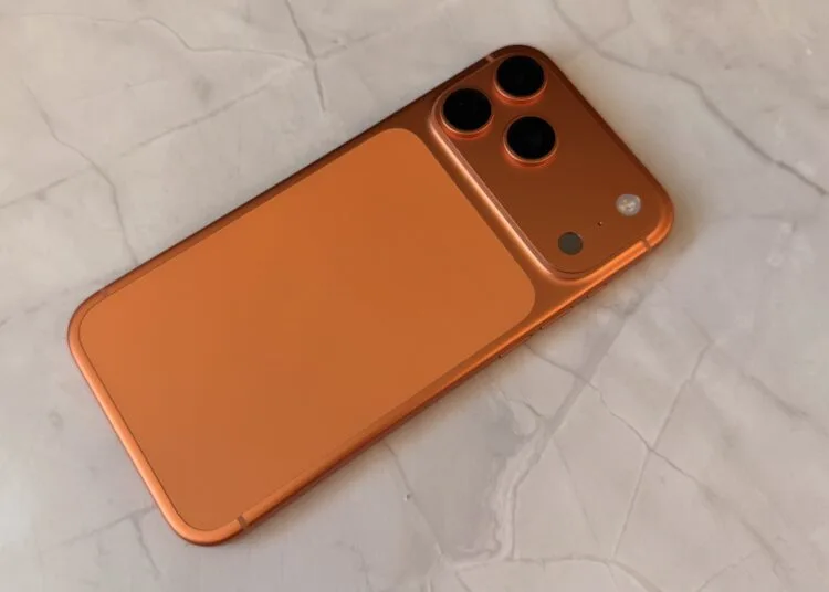 iPhone-Speicher 2027: Rückseite eines orangefarbenen iPhone mit Dreifach-Kamera auf einer hellen Marmorfläche