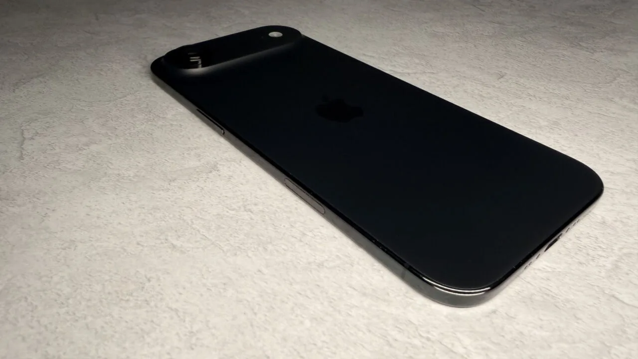 iPhone Ultra Marktanteil: flach liegendes schwarzes iPhone Air von der Seite auf hellem Stein