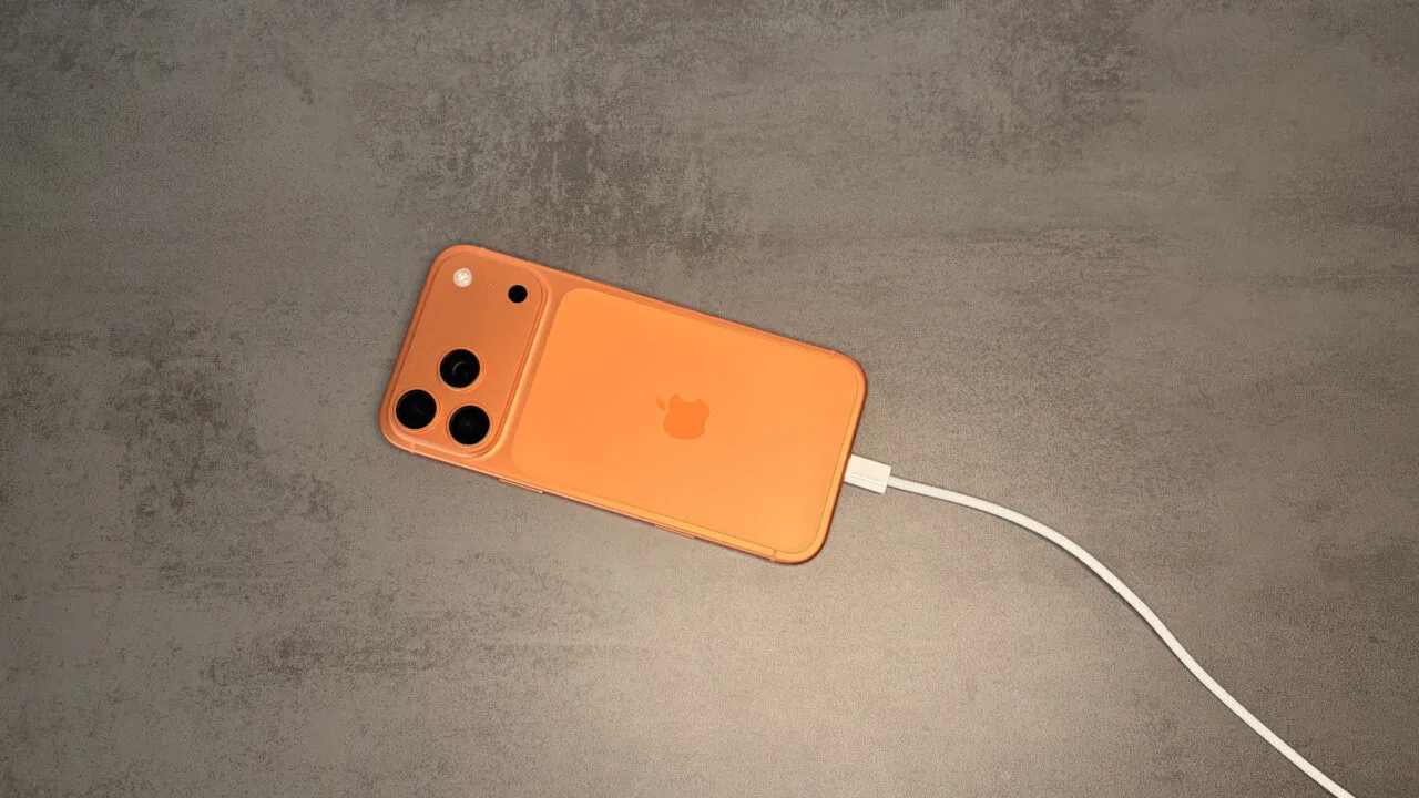 iPhone in oranger Hülle am USB-C-Kabel, Ausgangspunkt für Juice Jacking an fremden Anschlüssen