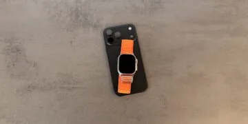 Taptic Engine Urteil: schwarzes iPhone mit Dreifachkamera, darauf eine Apple Watch Ultra mit orangefarbenem Alpine Loop