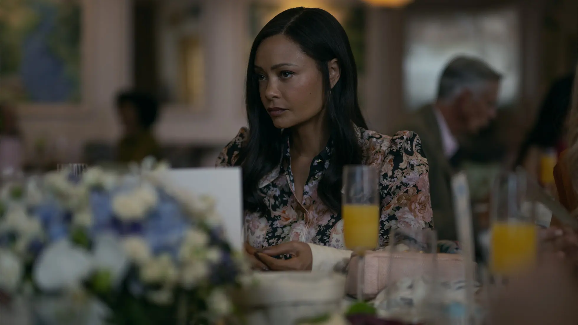 Thandiwe Newton in geblümter Bluse an einem gedeckten Tisch, Szene aus The Wanted Man bei Apple TV