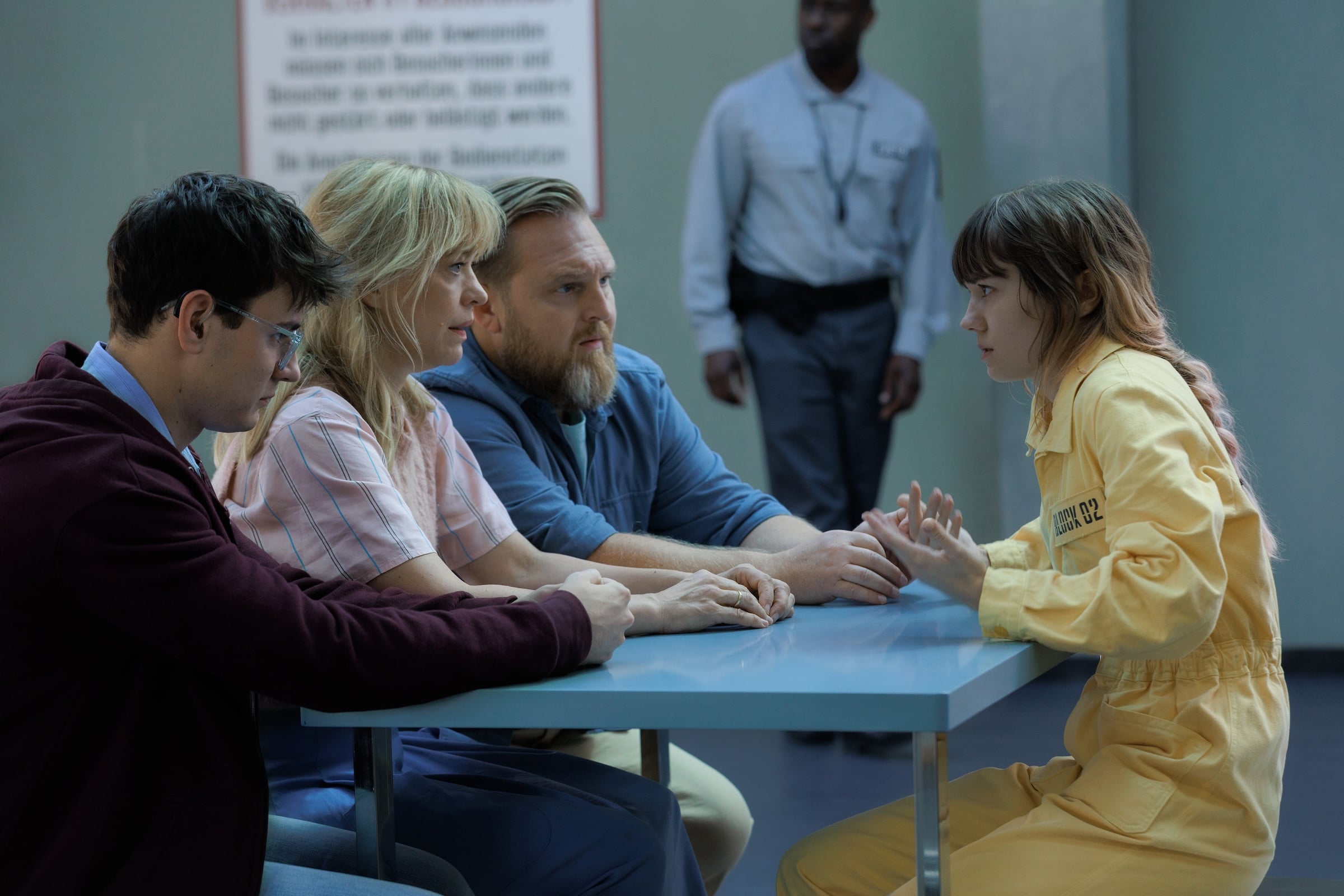 Apple TV October 2026: the Klatt family sits at a table in a prison visiting room facing daughter Wanda in a yellow jumpsuit, scene from Where's Wanda? season 2