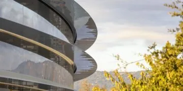 Glasfassade des Apple Park mit geschwungenen Vordächern in der Abendsonne – Apple sichert sich Team und Patente von Ascend.io