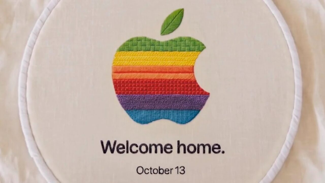 Apple-Event 13. Oktober: Gesticktes Apple-Logo in Regenbogenfarben im Stickrahmen mit dem Schriftzug „Welcome home.“ und „October 13“