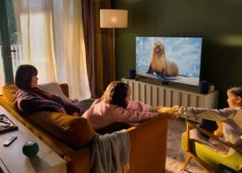 Apple Event Welcome home: Familie im Wohnzimmer vor einem Fernseher mit Apple TV, daneben zwei HomePod und hinter dem Sofa zwei grüne HomePod mini