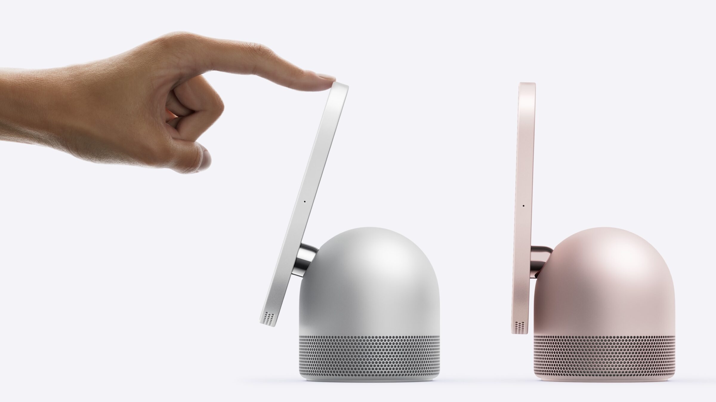 A hand tilts the display of Apple HomeView on its hinge above the domed speaker base, next to a second model in pink