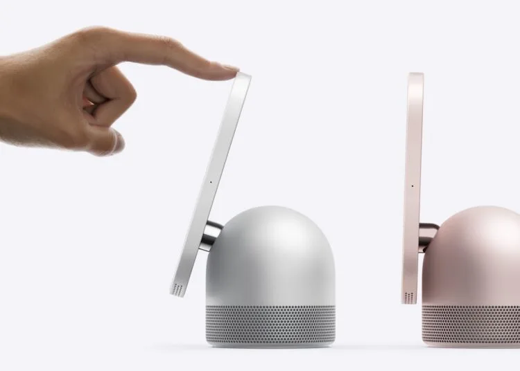 HomeView Roboterarm: Eine Hand neigt mit einem Finger das Display einer silbernen HomeView, daneben steht ein zweites Modell in Rosa