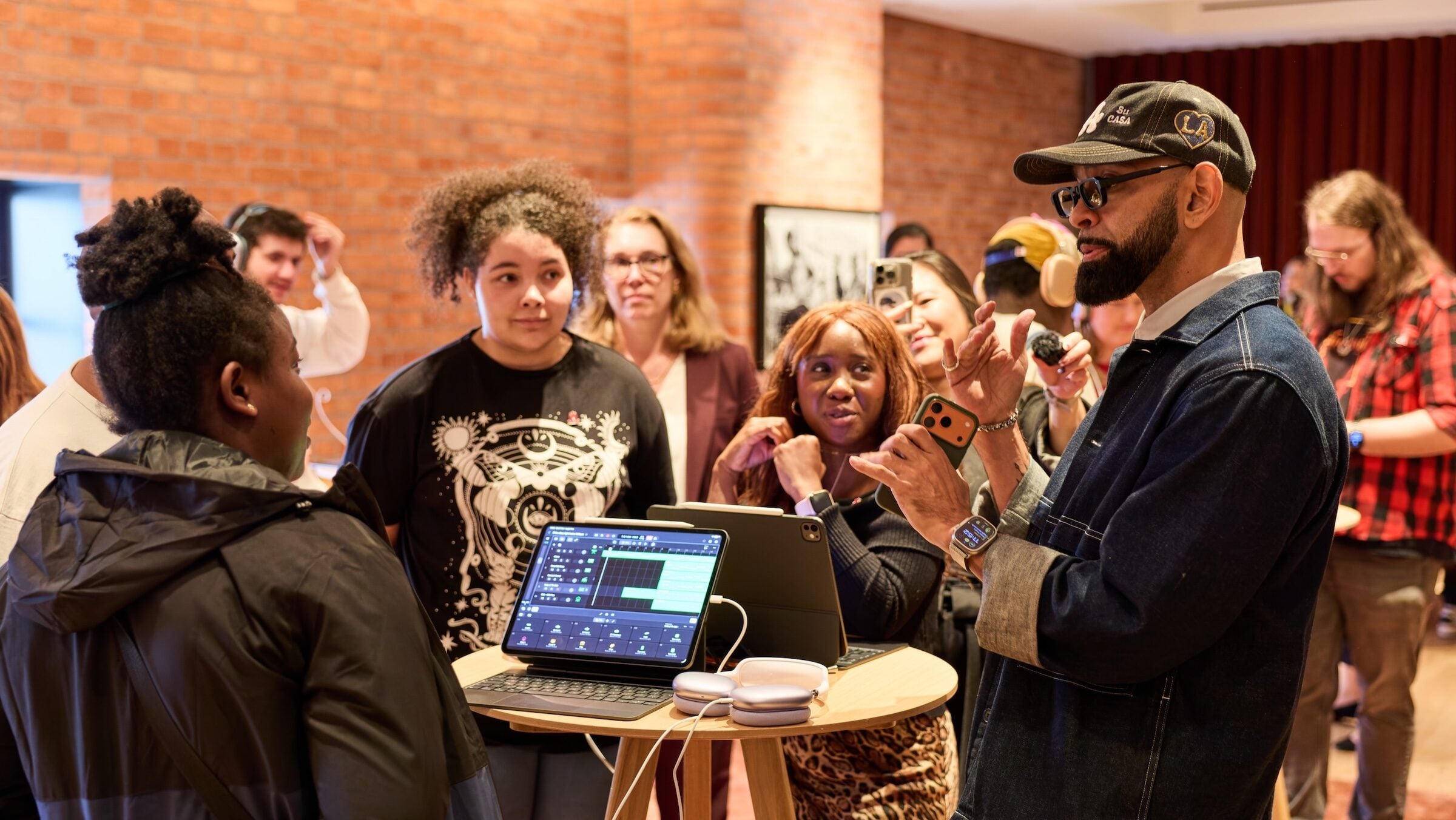 Apple King's Trust: Workshop leader explaining music production on iPad to Creative Labs participants, AirPods Max beside it