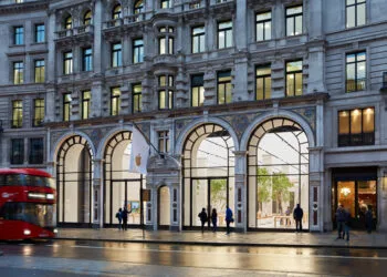 Apple Store Regent Street in London in der Abenddämmerung mit vier Glasbögen, weißer Apple-Fahne und rotem Doppeldeckerbus, Symbol für die Apple Stores, die Kartons mit Sperrfrist erhalten haben