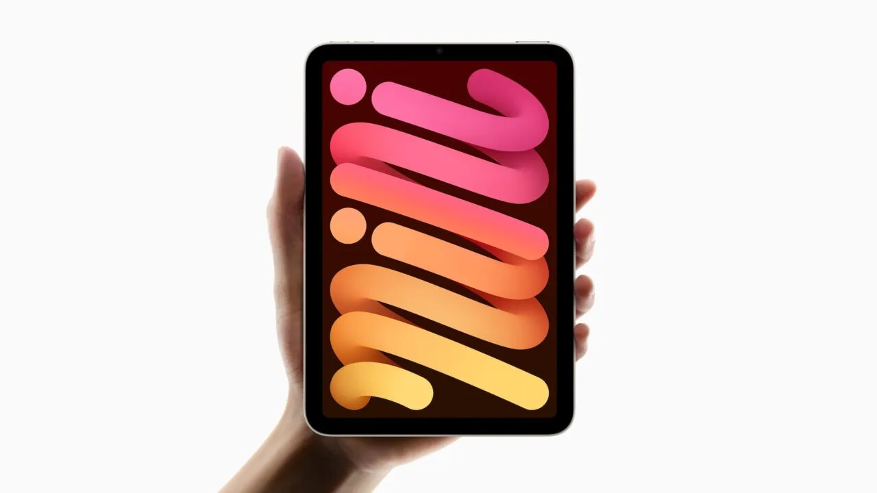 Zum iPad mini 8 Smart Folio: das bisherige iPad mini mit hellem Rahmen hochkant in einer Hand, auf dem Display ein Hintergrundbild aus rosa und orangen Bändern