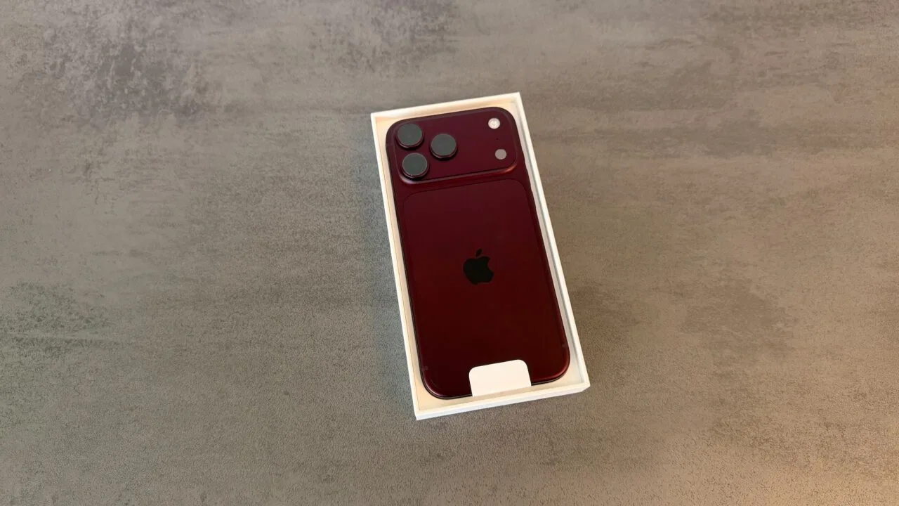 iPhone 18 Pro Absatz: ein iPhone 18 Pro in Burgunderrot liegt mit der Rückseite nach oben in der geöffneten weißen Verpackung auf grauem Stein