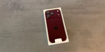 iPhone 18 Pro Absatz: ein iPhone 18 Pro in Burgunderrot liegt mit der Rückseite nach oben in der geöffneten weißen Verpackung auf grauem Stein