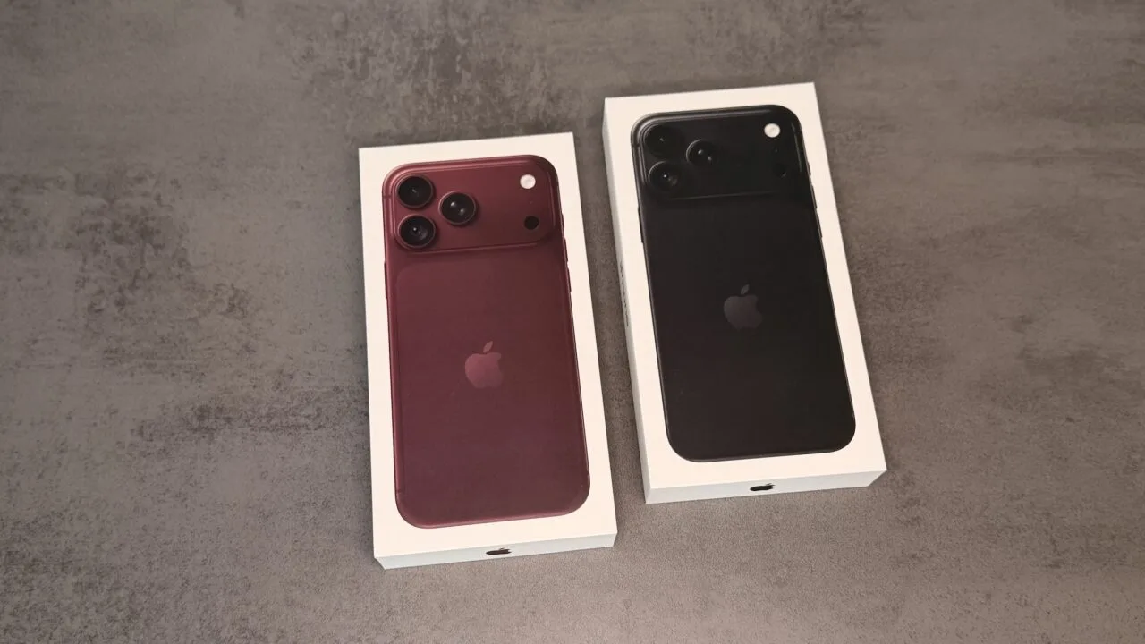 Zwei Verpackungen des iPhone 18 Pro in Burgunder und Schwarz auf einer grauen Fläche