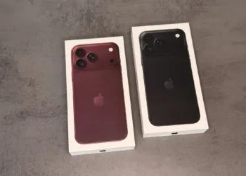 Zwei Verpackungen des iPhone 18 Pro in Burgunder und Schwarz auf einer grauen Fläche