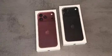 Zwei Verpackungen des iPhone 18 Pro in Burgunder und Schwarz auf einer grauen Fläche