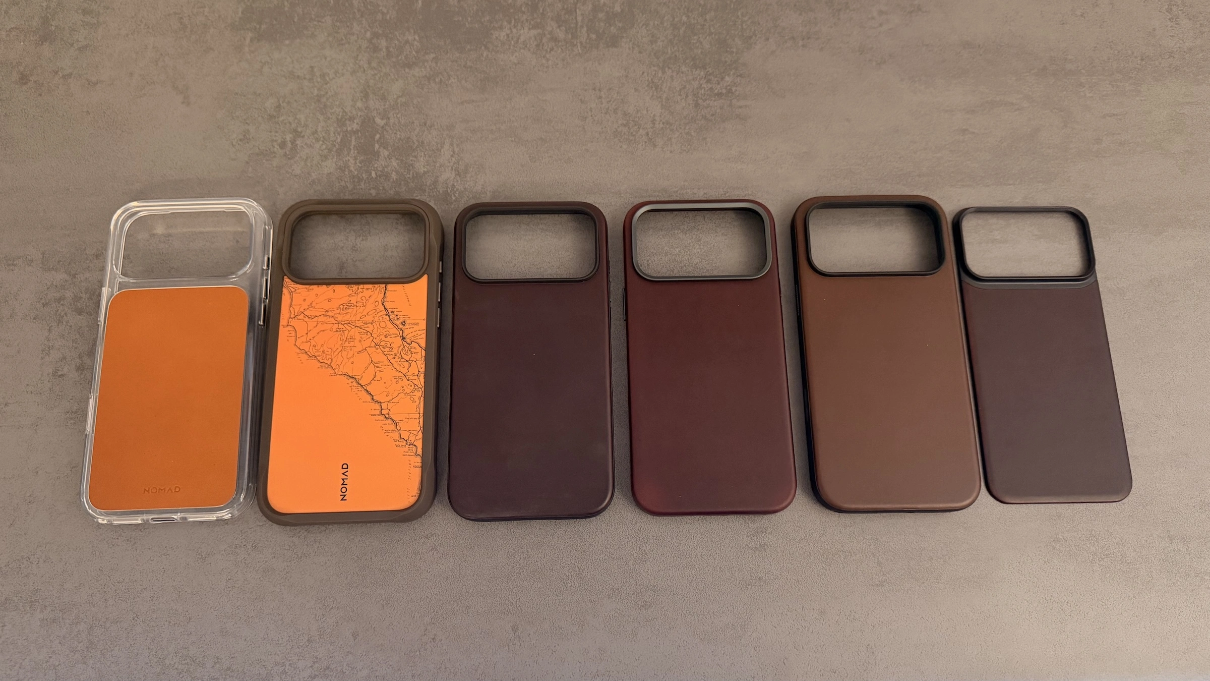 Nomad Hüllen iPhone 18 Pro: Clear Leather Case, Rugged Case, zwei Modern Leather Cases, Traditional Leather Case und Mag Leather Back in einer Reihe