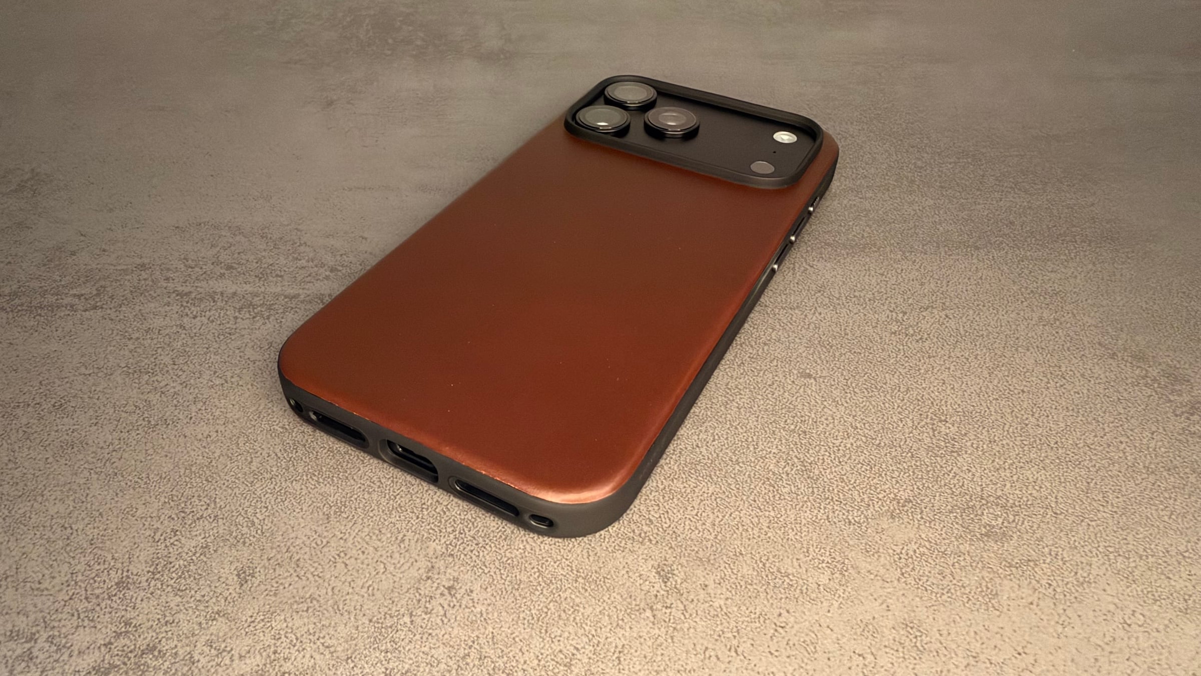 Nomad cases iPhone 18 Pro: Modern Leather Case in Rustic Brown with black bumper and cutouts on the bottom edge