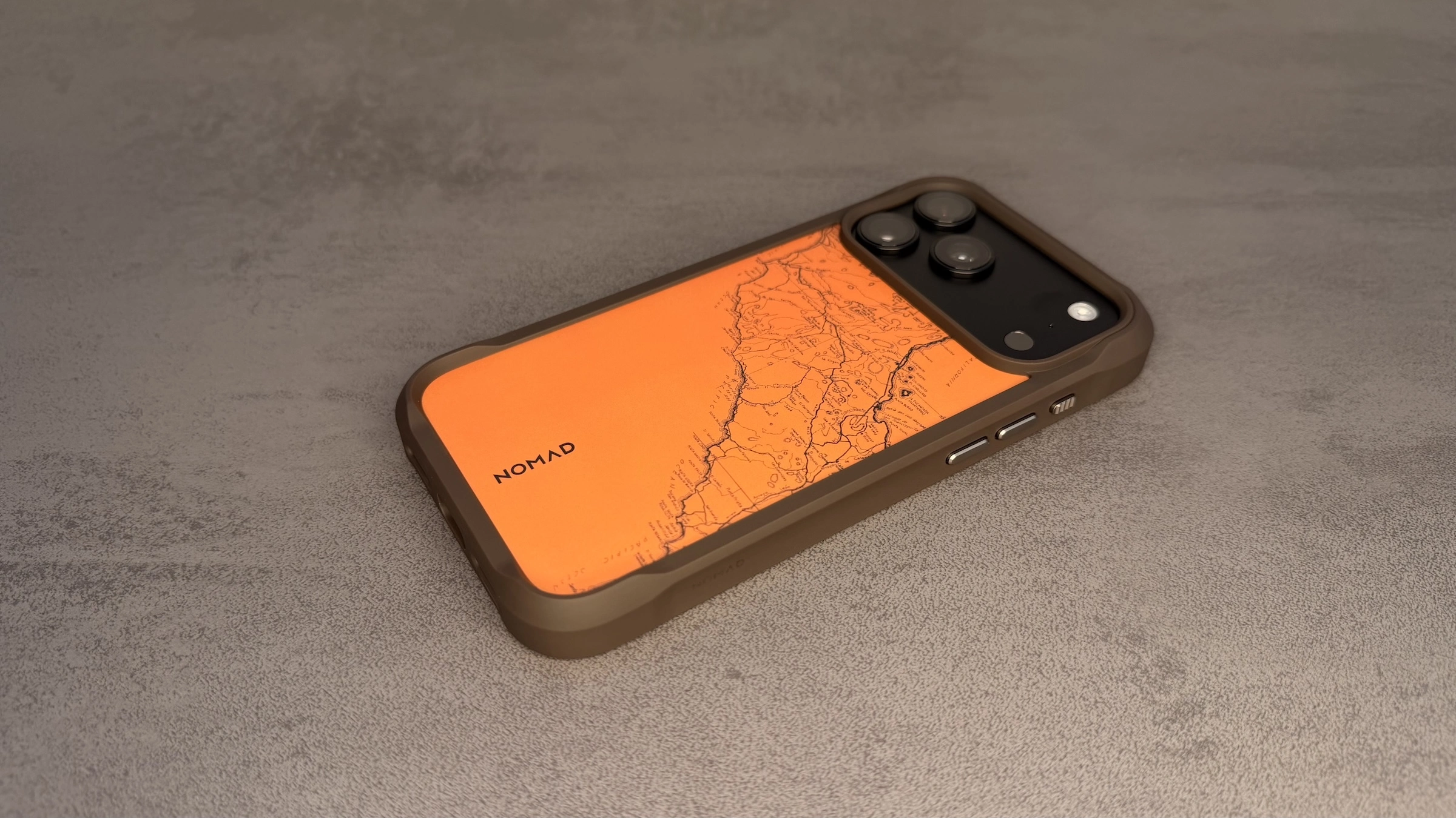 Nomad Hüllen iPhone 18 Pro: Rugged Case in Arroyo mit orangefarbener Rückplatte, eingravierter Landkarte und verstärkten Ecken