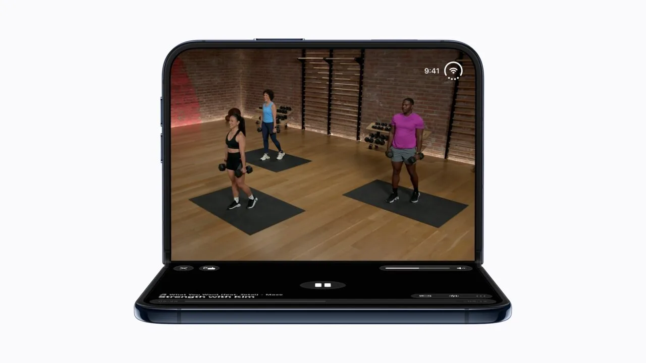 iPhone Duo Akku: das halb aufgeklappte iPhone Duo zeigt oben ein Workout-Video mit drei Trainierenden, unten die Steuerung der Wiedergabe