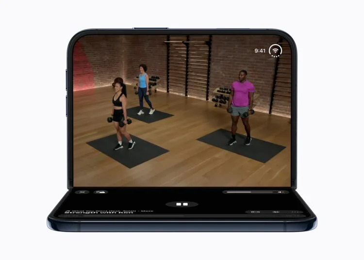 iPhone Duo Akku: das halb aufgeklappte iPhone Duo zeigt oben ein Workout-Video mit drei Trainierenden, unten die Steuerung der Wiedergabe