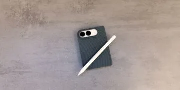 Zugeklapptes iPhone Duo in einer dunklen Hülle auf einer grauen Steinoberfläche, darauf ein weißer Apple Pencil – so sieht das iPhone Duo mit Apple Pencil aus