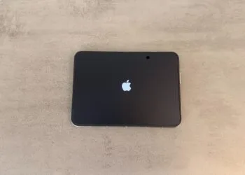 iPhone Duo Rückruf: aufgeklapptes iPhone Duo liegt flach auf einem grauen Tisch, das Innendisplay zeigt beim Start das Apple-Logo