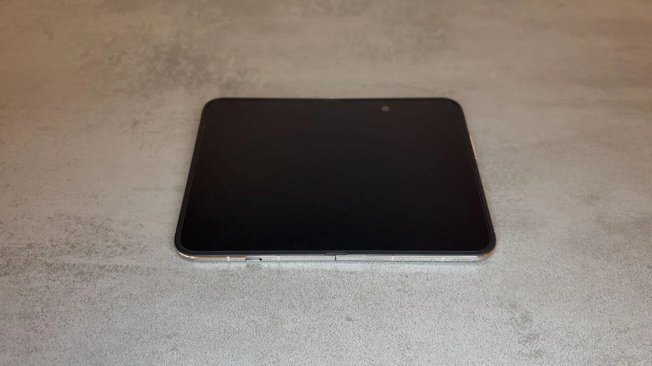 iPhone Duo Innendisplay: das aufgeklappte iPhone Duo liegt flach auf einem grauen Tisch, das Display ist ausgeschaltet