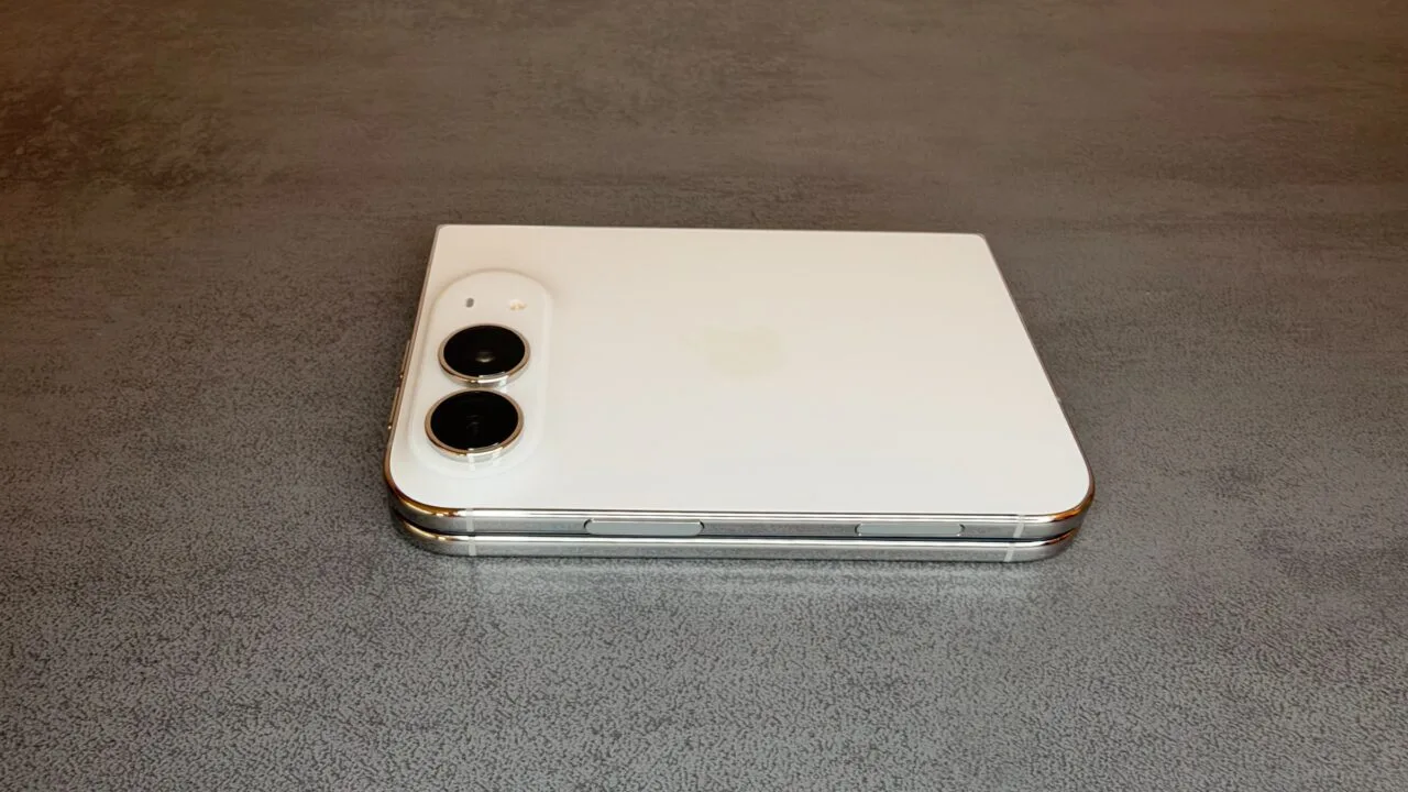 iPhone Duo Kamera-Vorschau: das zugeklappte iPhone Duo in Weiß liegt auf einem grauen Tisch, oben links die beiden rückseitigen Kameras