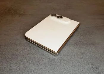Zum iPhone Duo Reparaturhandbuch: das zugeklappte iPhone Duo in Sternenweiß auf einem Tisch, mit Rückglas, Kamera, Scharnier und USB-C-Anschluss.