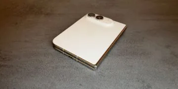 Zum iPhone Duo Reparaturhandbuch: das zugeklappte iPhone Duo in Sternenweiß auf einem Tisch, mit Rückglas, Kamera, Scharnier und USB-C-Anschluss.