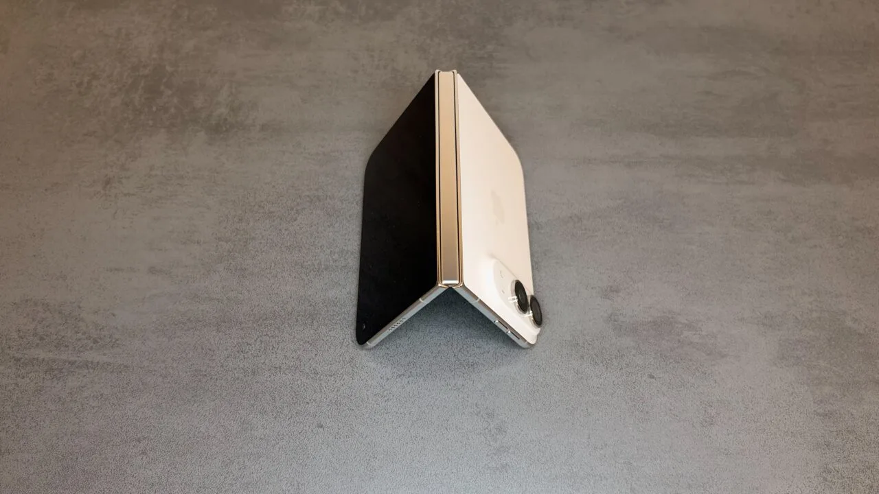 iPhone Duo Teardown: halb aufgeklapptes iPhone Duo in Sternenweiß, als Zelt aufgestellt, mit dem Scharnier in der Bildmitte