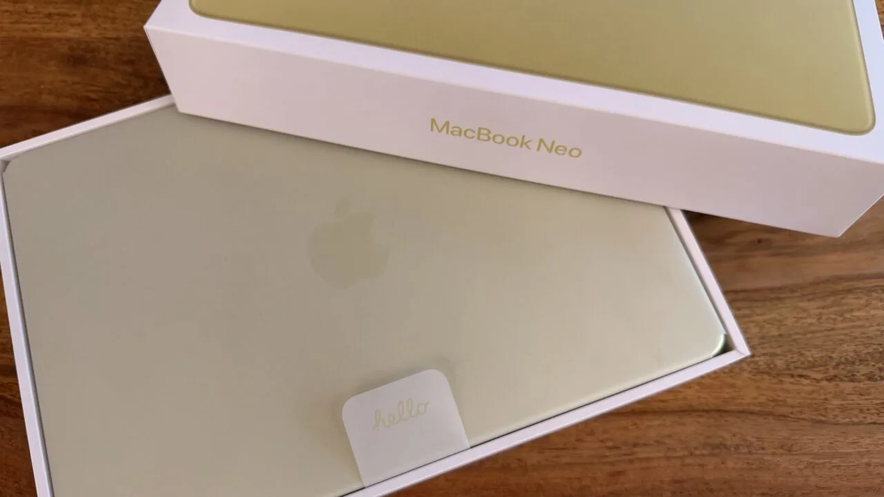 Frisch ausgepacktes MacBook Neo in Gelb mit Hello-Lasche im Karton auf einem Holztisch – Symbolbild zu den Mac-Auslieferungen im dritten Quartal