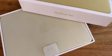 Frisch ausgepacktes MacBook Neo in Gelb mit Hello-Lasche im Karton auf einem Holztisch – Symbolbild zu den Mac-Auslieferungen im dritten Quartal
