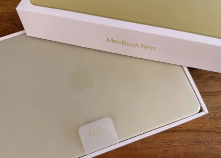 Frisch ausgepacktes MacBook Neo in Gelb mit Hello-Lasche im Karton auf einem Holztisch – Symbolbild zu den Mac-Auslieferungen im dritten Quartal