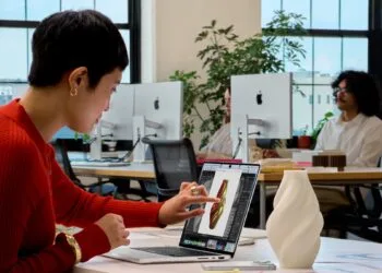 MacBook Pro Touch: Eine Frau tippt auf das Display eines MacBook Pro und bearbeitet dort das 3D-Modell einer Vase