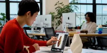 MacBook Pro Touch: Eine Frau tippt auf das Display eines MacBook Pro und bearbeitet dort das 3D-Modell einer Vase