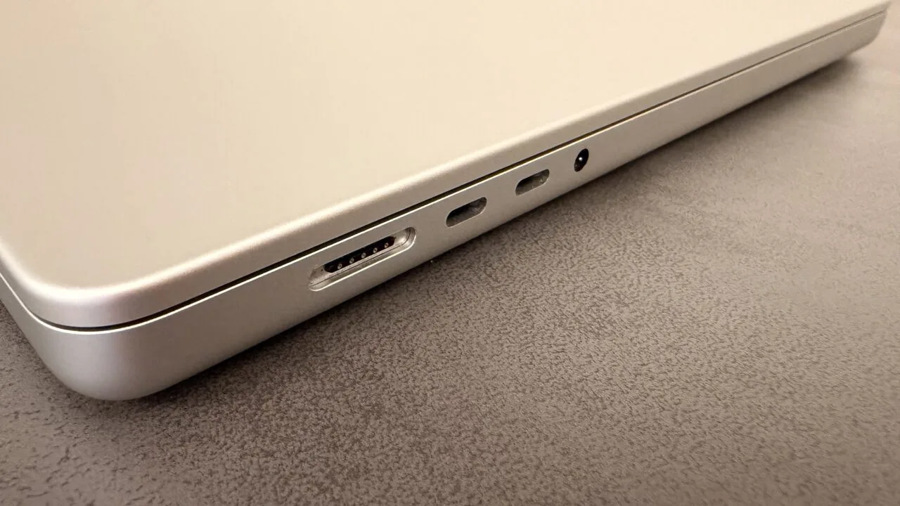 Silbernes MacBook auf einer dunklen Tischplatte, Blick auf MagSafe-Anschluss, zwei USB-C-Anschlüsse und Kopfhörerbuchse – Symbolbild zum Notebook-Markt 2027